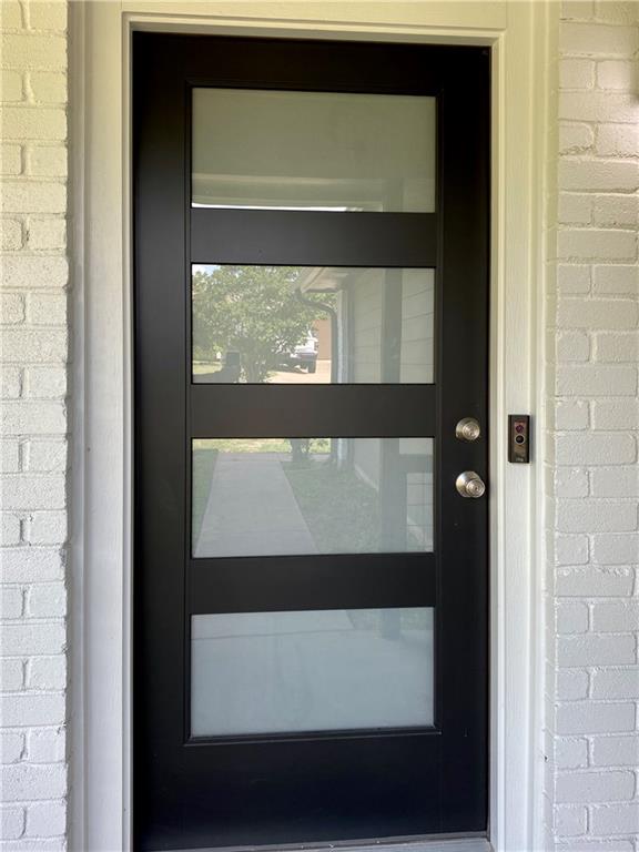1715 Shadowview Drive, Unit B Austin, TX 78758 - Photo 9 of 28 A contemporary front entry features a striking black door with multiple clear and frosted glass panels.