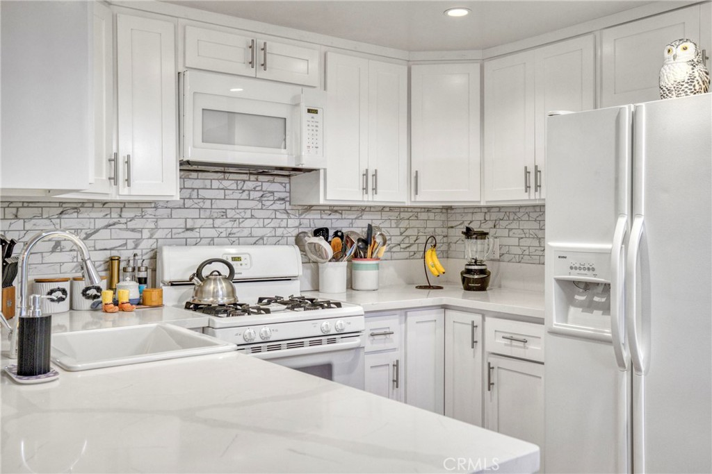 15155 Sherman Way, Unit 14 Van Nuys, CA 91405 - Photo 14 of 36 a kitchen with stainless steel appliances a refrigerator sink and cabinets