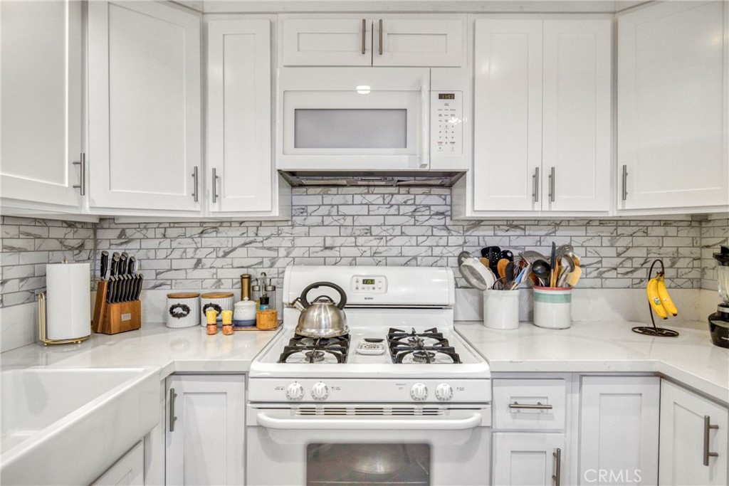 15155 Sherman Way, Unit 14 Van Nuys, CA 91405 - Photo 16 of 36 a kitchen with white cabinets and white appliances