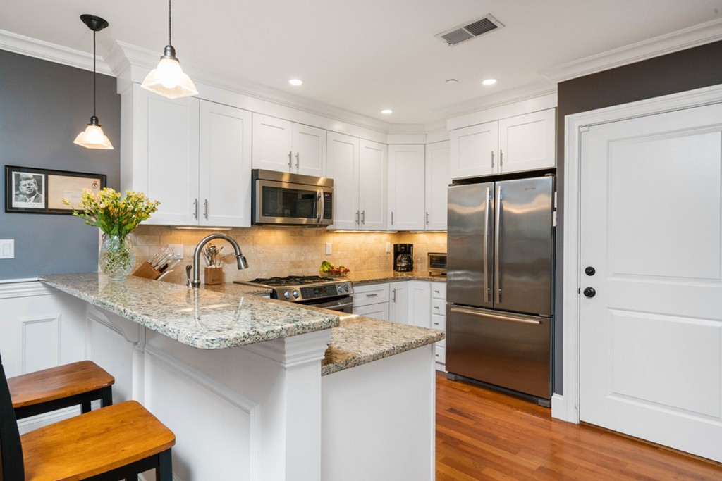 a kitchen with kitchen island granite countertop stainless steel appliances and a sink