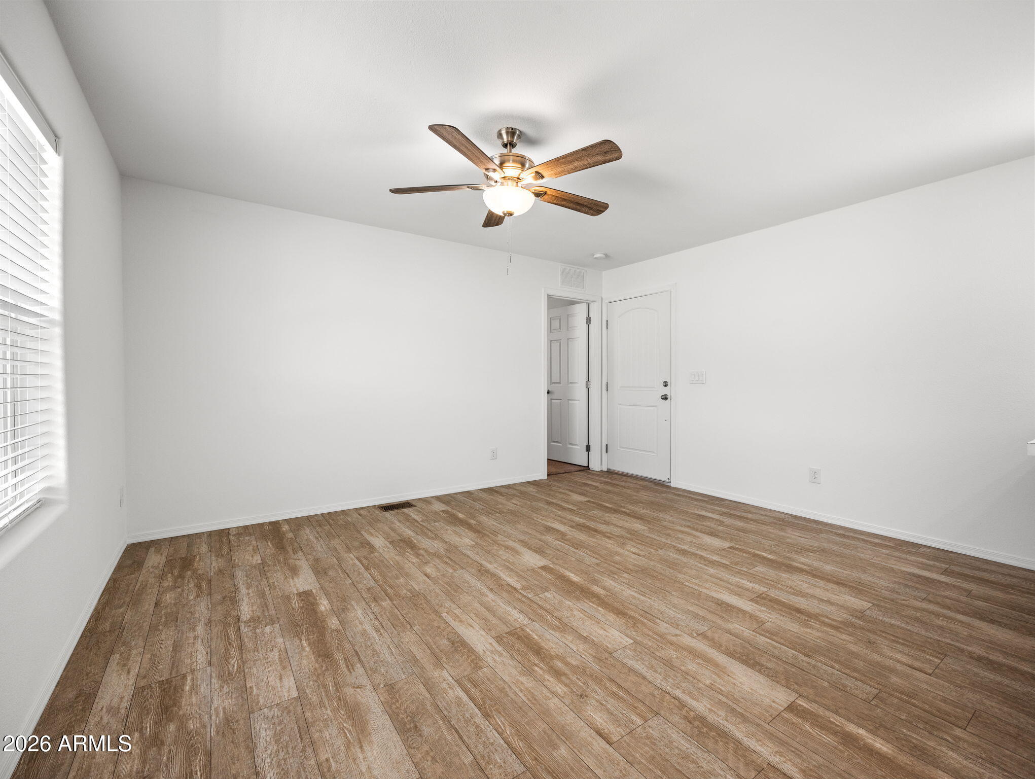 18296 Frontier Road Peeples Valley, AZ 86332 - Photo 14 of 44 an empty room with windows and fan