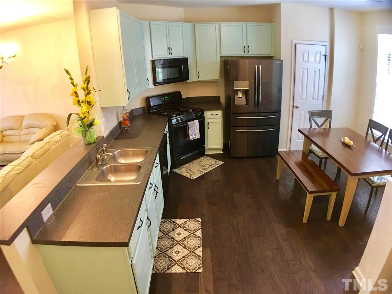 4433 Moss Garden Path Raleigh, NC 27616 - Photo 5 of 20 a kitchen with stainless steel appliances a refrigerator a stove a microwave a sink and white cabinets