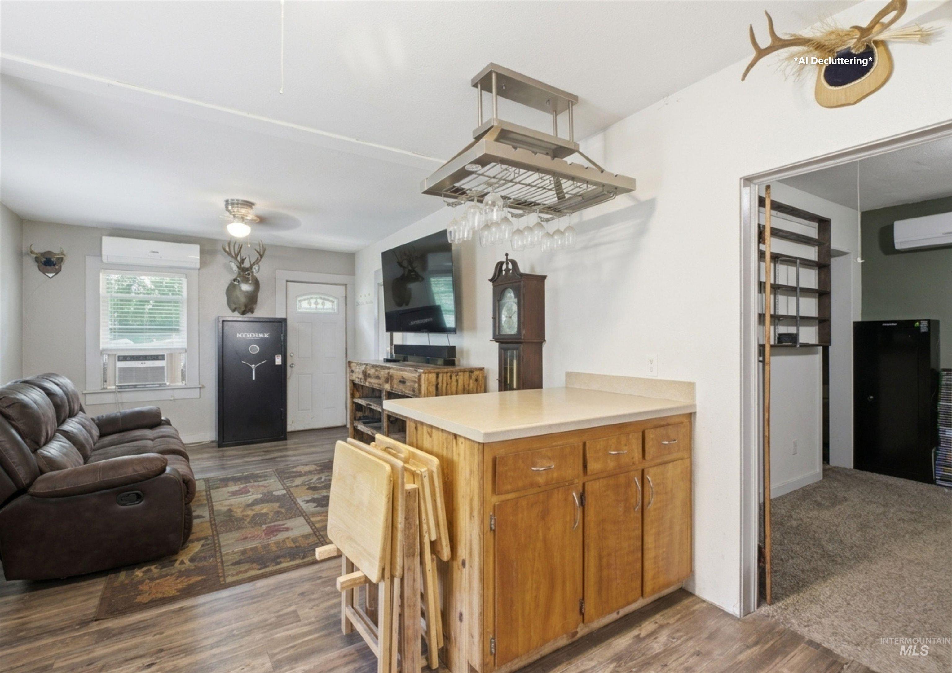 735 Oak Street Potlatch, ID 83855 - Photo 8 of 30 Open-concept living area featuring wood-finish flooring, a white paneled entry door, and a built-in wood-tone bar with a light countertop