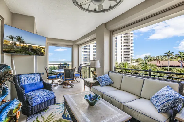 a living room with furniture and floor to ceiling windows