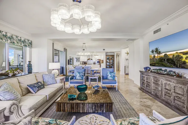a living room with furniture a chandelier and a flat screen tv