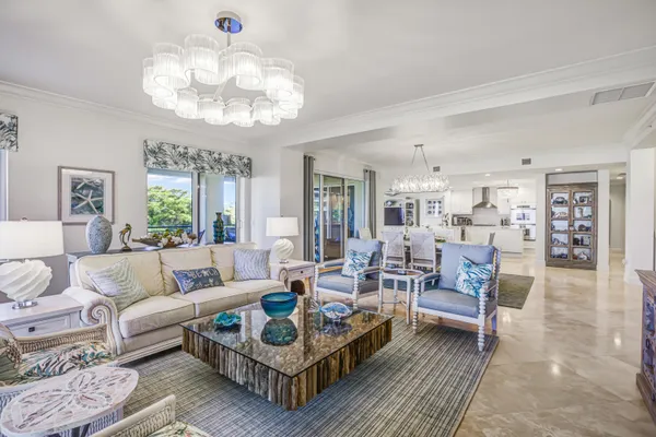 a living room with furniture a chandelier and a rug