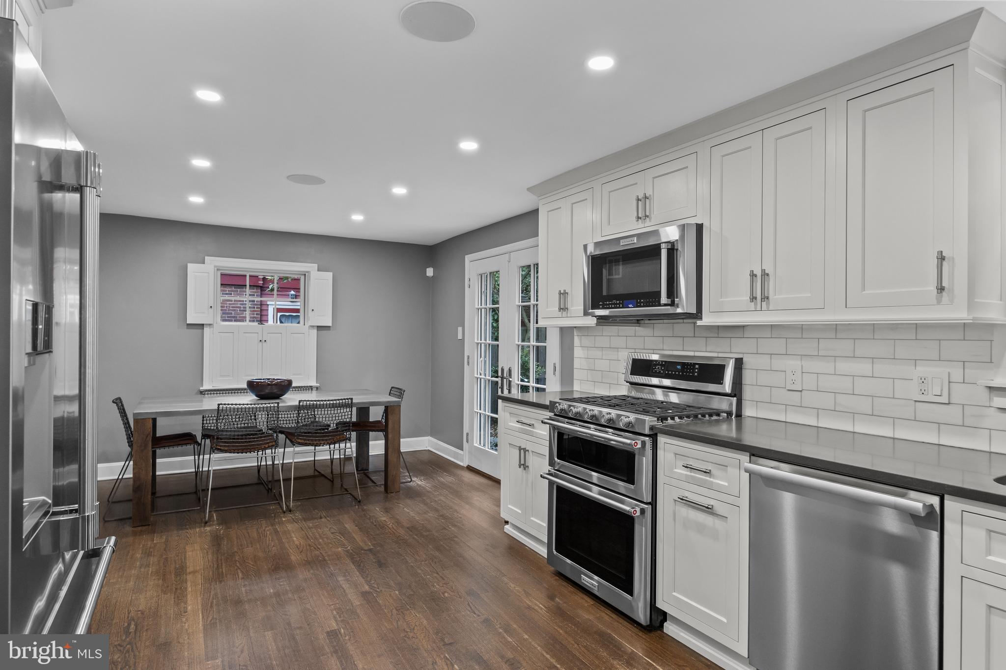 219 West Summit Avenue Haddonfield, NJ 08033 - Photo 9 of 29 a kitchen with stainless steel appliances granite countertop a stove top oven a sink dishwasher a dining table and chairs with wooden floor