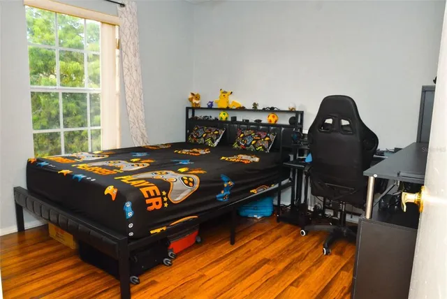 a bedroom with a bed and wooden floor