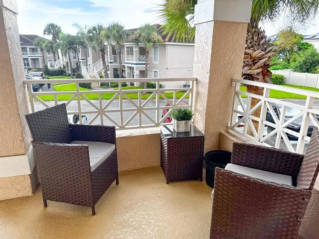 a balcony with outdoor seating and yard