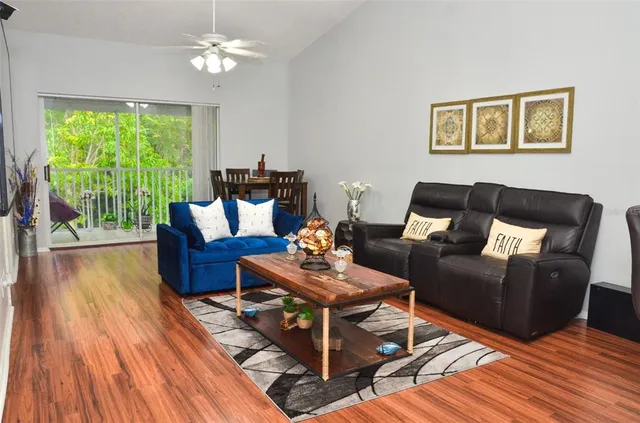 a living room with furniture and a wooden floor