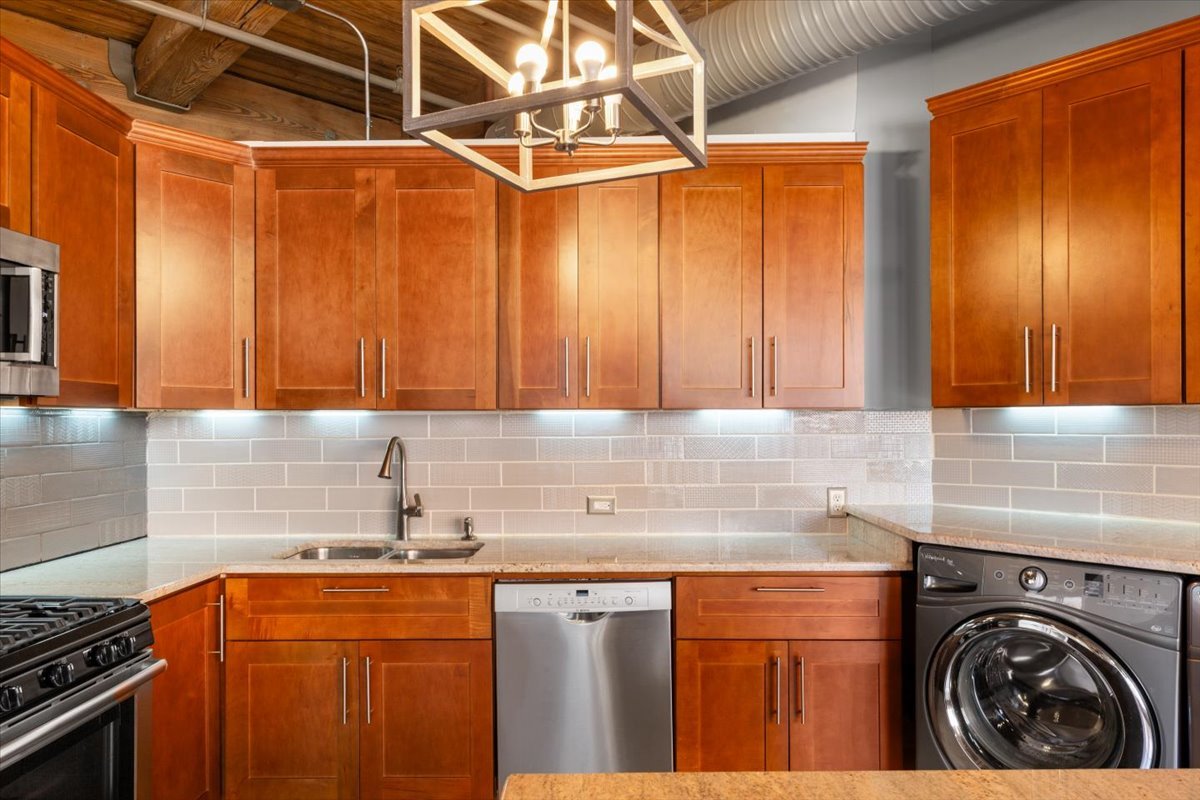 913 West Van Buren Street, Unit 4C Chicago, IL 60607 - Photo 15 of 23 a kitchen with stainless steel appliances granite countertop a sink a stove and a refrigerator