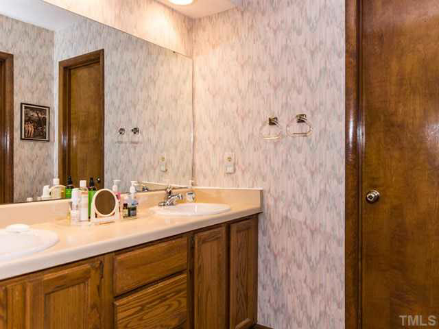 1212 Stone Creek Way Raleigh, NC 27615 - Photo 18 of 25 The dual vanity with wood cabinets is a great feature in the master bathroom. The inner bathroom features a tiled shower.