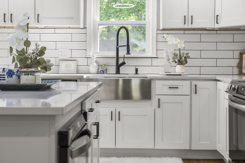 102 Hathaway Circle Arlington, MA 02476 - Photo 12 of 38 a kitchen with stainless steel appliances granite countertop a sink a stove and a white cabinets