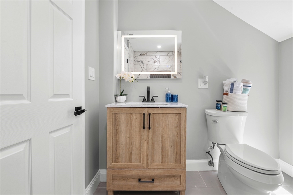 102 Hathaway Circle Arlington, MA 02476 - Photo 14 of 38 a bathroom with a toilet a sink a vanity and mirror