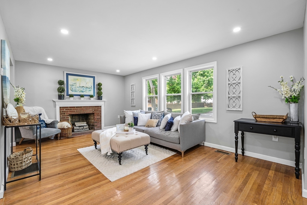 102 Hathaway Circle Arlington, MA 02476 - Photo 17 of 38 a living room with furniture a fireplace and a floor to ceiling window
