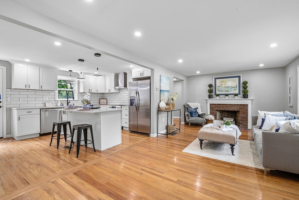 102 Hathaway Circle Arlington, MA 02476 - Photo 26 of 38 a living room with furniture a fireplace and kitchen view