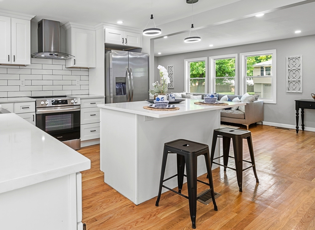 102 Hathaway Circle Arlington, MA 02476 - Photo 29 of 38 a kitchen with a table chairs stove and cabinets