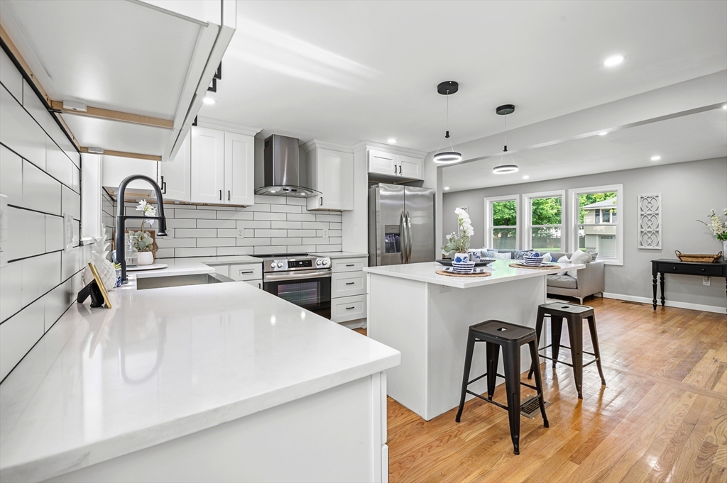 102 Hathaway Circle Arlington, MA 02476 - Photo 32 of 38 a kitchen with stainless steel appliances a sink a stove a refrigerator cabinets and dining table
