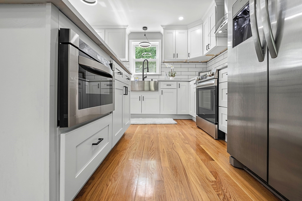 102 Hathaway Circle Arlington, MA 02476 - Photo 9 of 38 a view of a hallway with wooden floor and staircase
