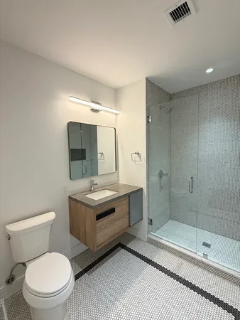 a bathroom with a sink a toilet and shower