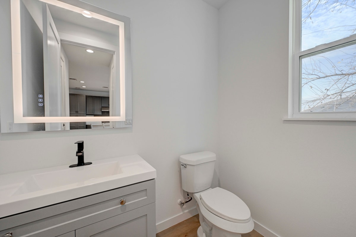 2220 Yellow Jacket Lane, Unit 1 Austin, TX 78741 - Photo 9 of 35 A well-lit powder room featuring a sleek vanity and an illuminated mirror for a modern touch.