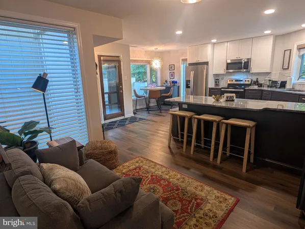 a kitchen with granite countertop a table chairs stove and refrigerator