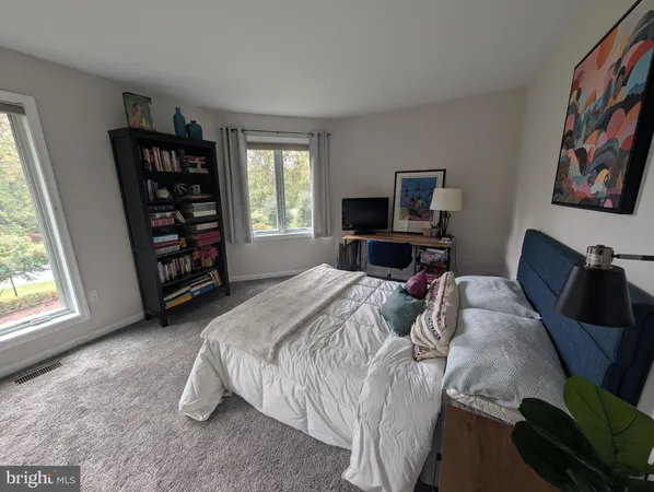 a bedroom with a bed a couch and dresser