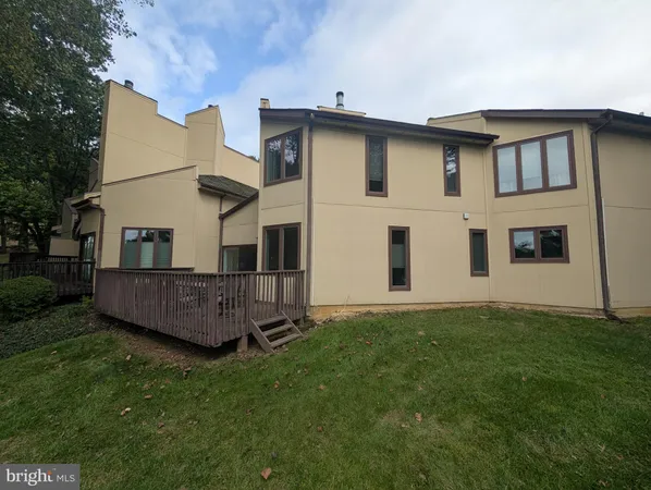 a view of a house with wooden deck and a yard
