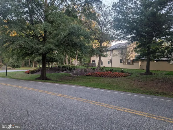 a view of a house with a big yard and large trees