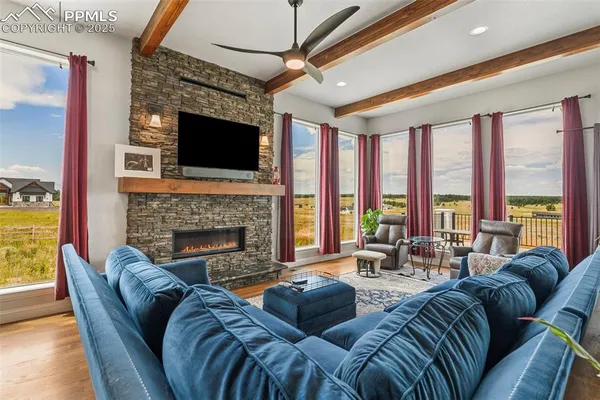a living room with furniture large windows and a fireplace