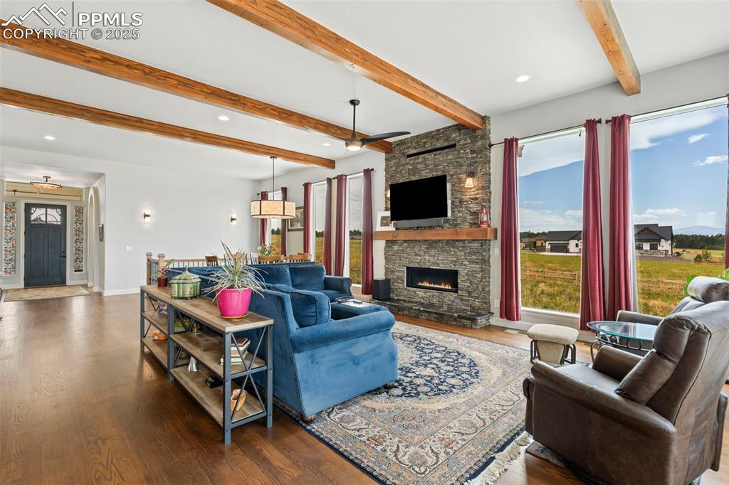 11726 Rambling Road Colorado Springs, CO 80908 - Photo 14 of 50 a living room with furniture a flat screen tv and a fireplace