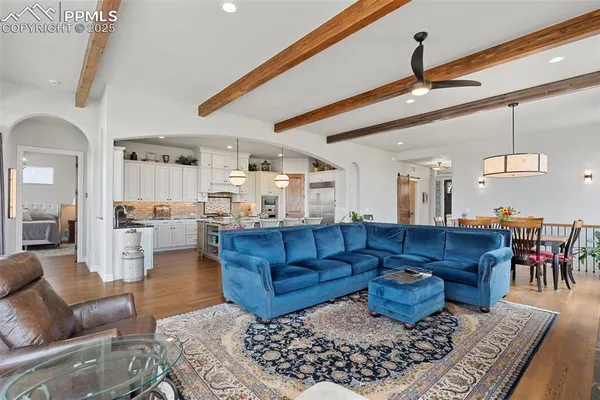 a living room with lots of furniture and view of kitchen