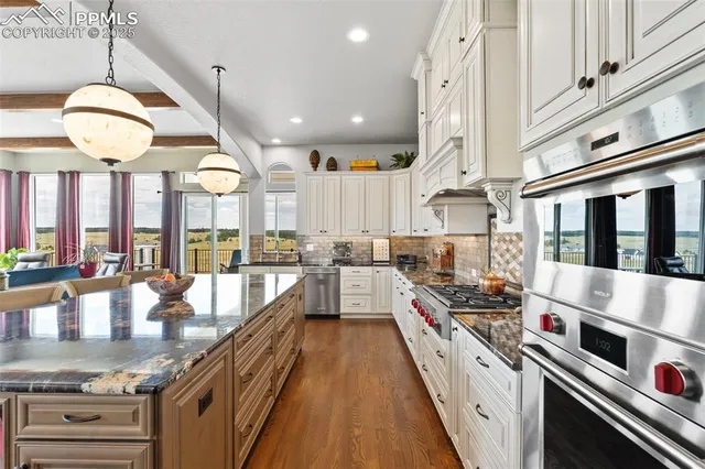a large kitchen with stainless steel appliances granite countertop a lot of counter space