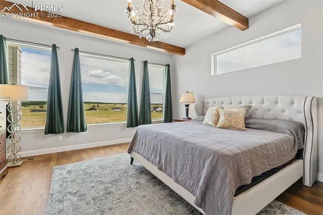 a bedroom with a large bed and a chandelier fan