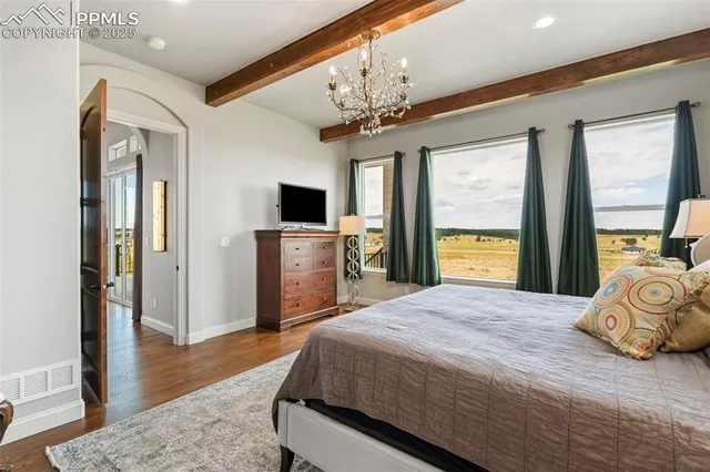 a spacious bedroom with a bed and a flat screen tv