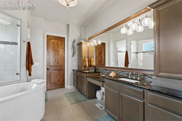 a bathroom with a granite countertop sink a large mirror and a bathtub