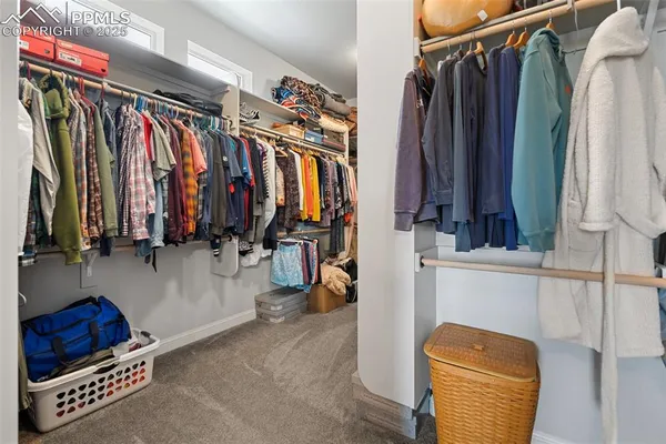 a view of walk in closet with clothes and shoes