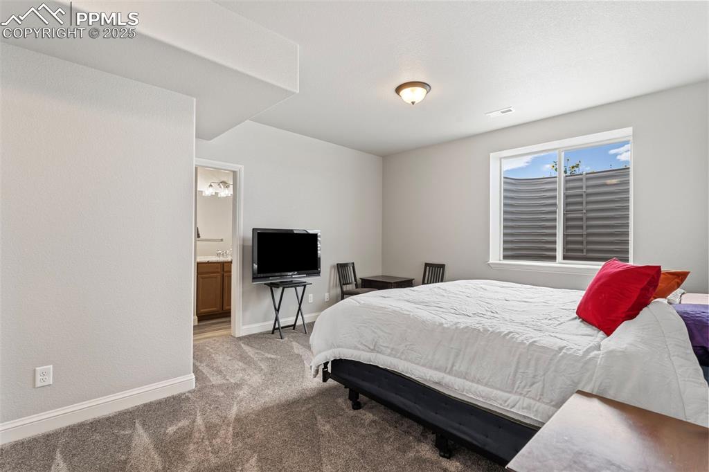 11726 Rambling Road Colorado Springs, CO 80908 - Photo 45 of 50 a bedroom with a bed and a flat screen tv