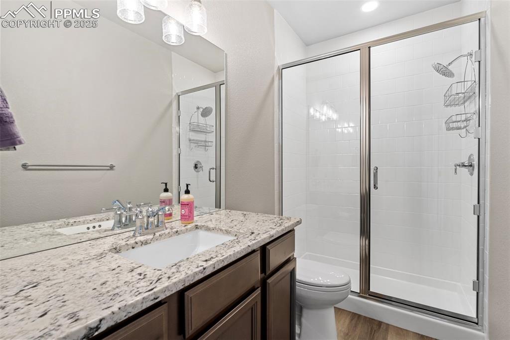 11726 Rambling Road Colorado Springs, CO 80908 - Photo 46 of 50 a bathroom with a granite countertop sink toilet and shower