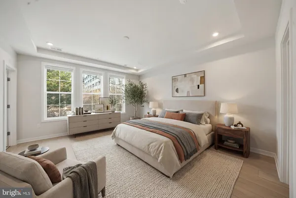 a spacious bedroom with a bed couch and a large window