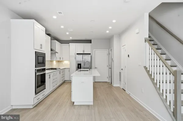 a kitchen with white cabinets and stainless steel appliances
