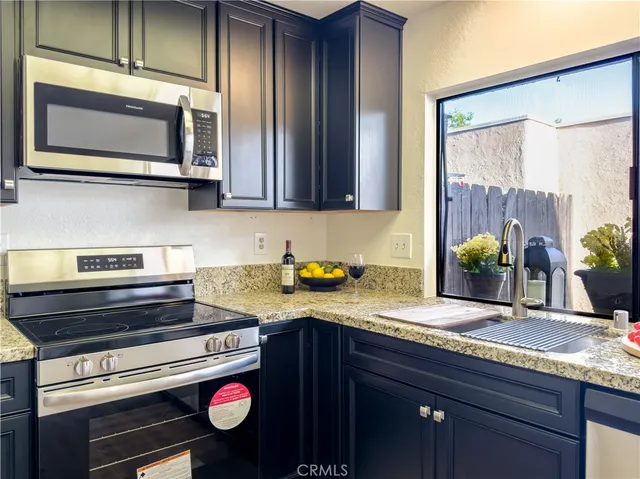 a kitchen with granite countertop stainless steel appliances and cabinets