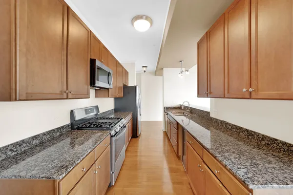 a large kitchen with stainless steel appliances granite countertop a stove and a refrigerator