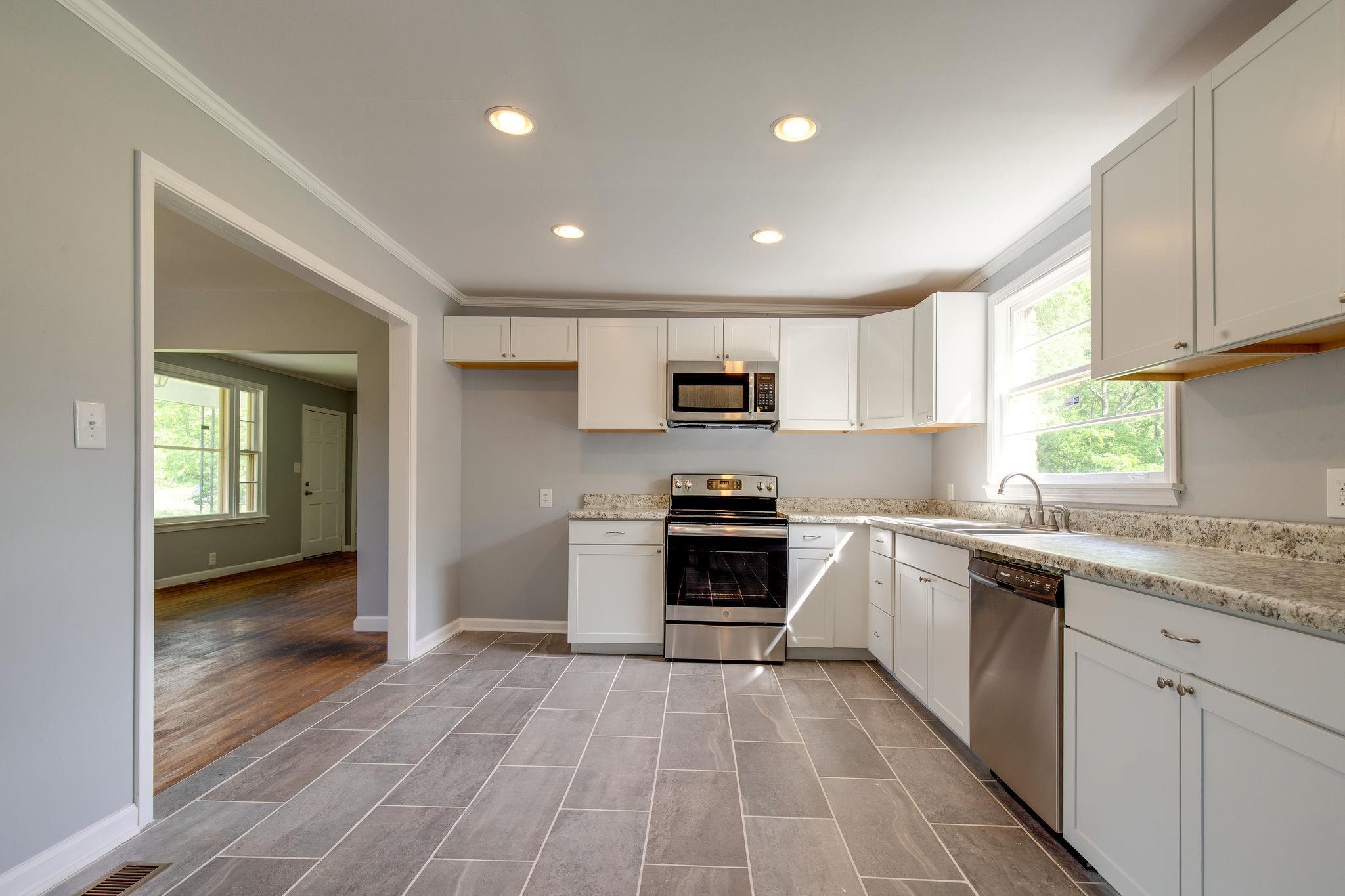 1008 Neelys Bend Road Madison, TN 37115 - Photo 8 of 26 a kitchen with granite countertop a stove top oven sink and cabinets
