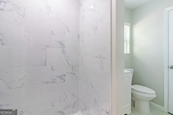 a bathroom with a toilet and a shower