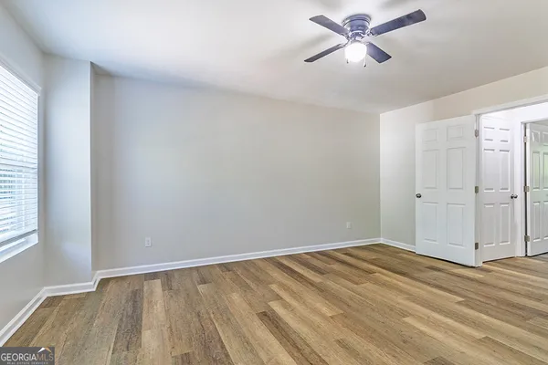 a view of a room with wooden floor and a ceiling fan