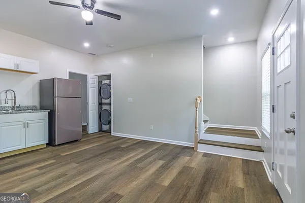 a view of a kitchen with refrigerator and wooden floor