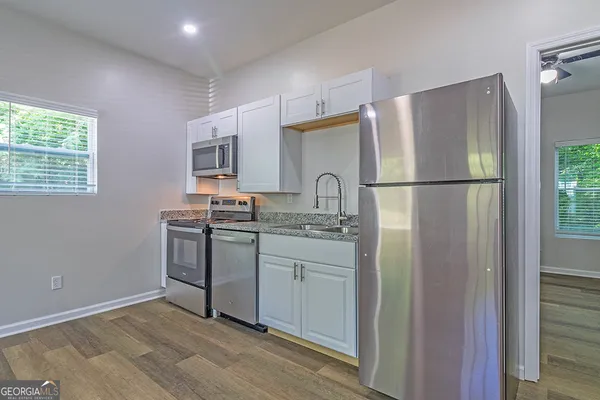 a kitchen with a refrigerator sink stove and cabinets