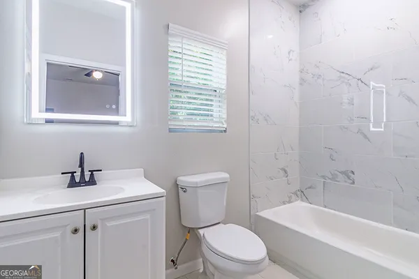 a bathroom with a toilet a sink and bathtub