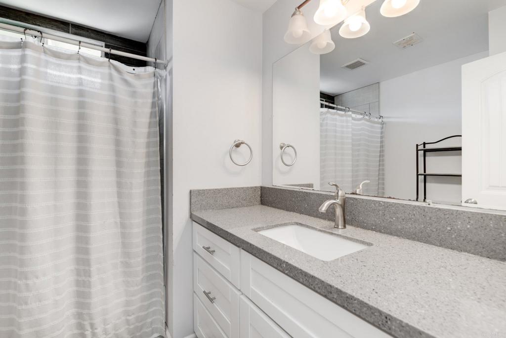 611 San Juhn Street Spring Valley, CA 91977 - Photo 14 of 25 a bathroom with a granite countertop sink and a mirror